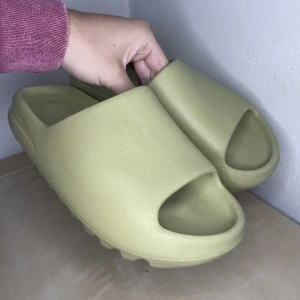 Adidas Yeezy Slide - Säljer dessa använda slides då jag tröttnat på dom.   Dessa slides är konstig i storlek. Dessa är 44 1/2 men passar mig perfekt som har storlek 42,5  Litet hål på sulan, därav priset