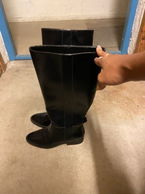 Oanvända boots - Boots i typ ridmodell, aldrig använda. Glansiga och låg klack så kan användas till vardags men ändå snygga 
