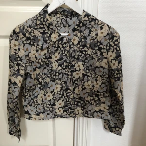 Blommig retro blus - Blommig retro blus i syntetiskt material!