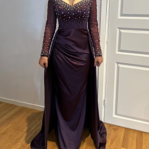 Balklänning  - En jätte fin och elegant balklänning i mörklila färg med pärlor. Är perfekt nyskick då den endast är använd en kväll några timmar.   Köpt i butik i Frankfurt för 300€   Passar storlek S/36