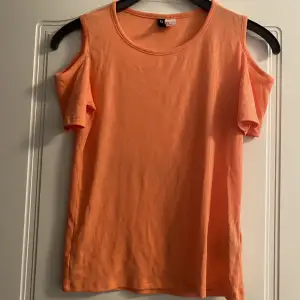 Fin t-shirts där axlarna syns. Cold shoulder T-shirt. Ser ut som ny och har en fin orange färg. Från H&M divided.