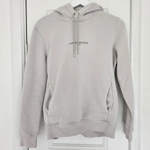Hoodie - Fin och stilren hoodie med liten text framtill ( andra bilden). Endast använts ett fåtal gånger hemma. Lite nopprig men annars i fint skick💕