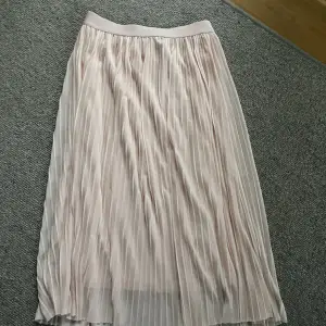 Ljustosa kjol med dubbeltyg som är pliserad. Säljer pågrund av att den ej används