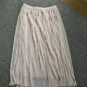 Kjol - Ljustosa kjol med dubbeltyg som är pliserad. Säljer pågrund av att den ej används