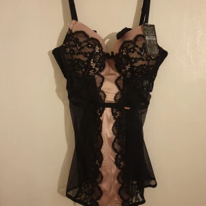 Hunkemöller Noir Amelia negligé  - Läcker negligé / underklänning  i svart och rosa med spetsdetaljer och strumpebandshållare.   Helt ny med prislapp kvar.   Present som tyvärr var för stor för mig :( Nypris 549 kr