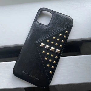 Mobilskal - Populärt skal från ideal of sweden för iPhone 11, använd en del därav lite söndrig som man ser på andra bilden och guldiga nitar istället för silvriga.