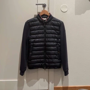 Moncler cardigan - Hej, säljer nu denna sjukt feta cardiganen i klassiska Navy färgen🔥 sizen är large och sitter tts. Skicket är utmärkt och ligger på 9/10. Priset är sjukt bra så först till kvarn!!!🥰 Vid frågor och funderingar är det bara att ta kontakt med mig🤝!