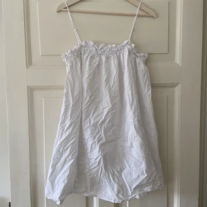 Vit klänning  - Kort, vit klänning med tunna axelband från HM  Storlek: M