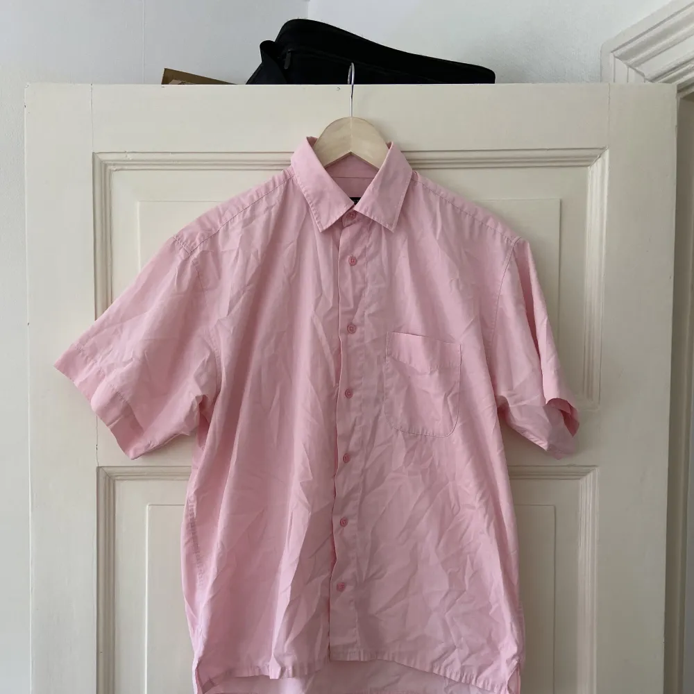 Kortärmad rosa skjorta. Osäker på material, kanske bomull/bomullsmix Storlek: M men stor i storleken/oversized. Blusar.