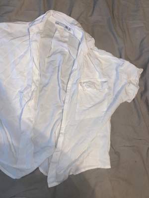 Kortärmad vit skjorta i ett väldigt mjukt material, den kommer inte till användning❤️ hör av er vid frågor 