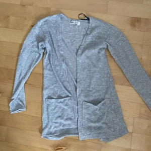 Silverglittrig kofta, barn - Silverglittrig kofta, tunn och stickad. Oanvänd i storlek 146/152.