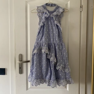 Randig klänning - Säljer denna supersnygga randiga klänningen med broderidetaljer från H&M. Klänningen har aldrig används och inte kommit till användning. 