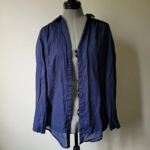 Tunn blå skjorta  - Tunn, blå skjorta som är lite genomskinlig.