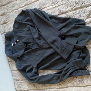 Svart skjorta  - Svart skjorta med fina detaljer , använd 1 gång 