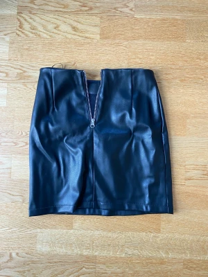 Skinnkjol - Säljer denna skinnkjol från bik bok. Den har en dragkedja där bak och är midwaist. Storlek 34/s. Säljer för 70kr+frakt.