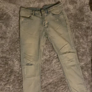 ÄKTA Ksubi Jeans Van Wrinkle Boneyard Phase Out 34” - Tvär feta äkta Ksubi Jeans som jag användt själv. Pågrund av det finns det en stor rip i baksidan som man kan se på andra bilden. Van Wrinkle Boneyard Phase Out storlek 34. Köp gärna för ett billigt pris och laga där bak själv rätt så enkelt Mvh Sebbe