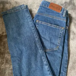 Ett par mörkblåa jeans. Dom är skinny jeans fast går ut lite vid smalbenen. 