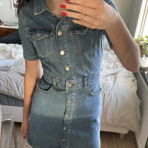 Jeansklänning nakd - Festlig blå jeansklänning, ”Button Up Mini Denim Dress” från nakd i strl. S. Knappt använd så i fint skick!💙