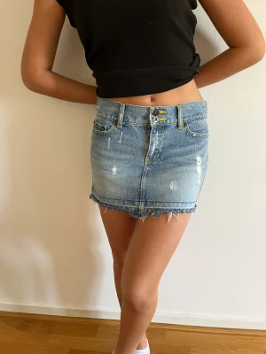 Von Dutch Mini Skirt - The model stands at a height of 167cm and maintains a weight of 54kg, typically fitting into clothing sizes XS/S.