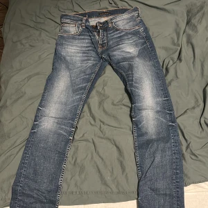 Nudie Jeans - Hej! Säljer ett par as feta Nudie Jeans i storlek 32/34. Skicket är nyskick, finns inga tecken på användning! Nypris på runt 1400kr. Tveka inte på att höra av er för mer bilder o info!🔥
