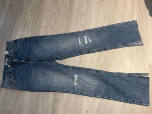 Blåa jeans  - Blåa jeans från pull&bear. Med slits nere vid foten. Använda 1 gång. Storlek 40 men mer som storlek 38 