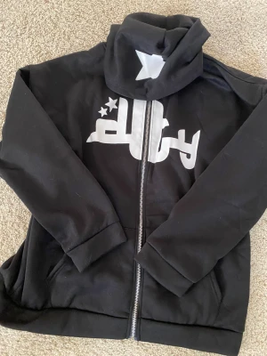Fet y2k zip up hoodie - Fet Svart y2k zip up hoodie som köptes för 500kr. Det står att den är 3xl men sitter som M-L. Om man har M blir det lite baggy men om man har L blir det helt perfekt 👌 aldrig använd