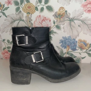 Låga stövletter  - Låga svarta stövletter med silvriga spännen. Väldigt välanvända. Storlek 39. 