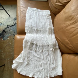 Vit långkjol - Vit långkjol med spets ”kanter”, endast använd någon enstaka gång 💓 är i storlek L men väldigt liten så skulle snarare säga att den är i M/S