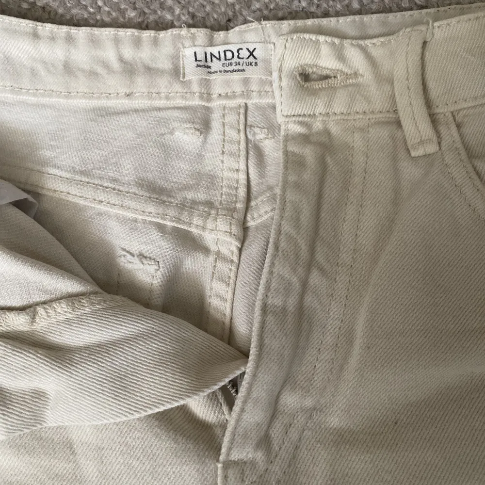 Fina vita jeans från Lindex som har använts ca 2 år. Inget slitage men säljer då det inte riktigt är min stil längre💓raka och vida i benen och i storlek 34💞lite blåfärgade på ena fickan från mobilskal men inget som syns jättetydligt💞skriv för fler frågor💞. Jeans & Byxor.