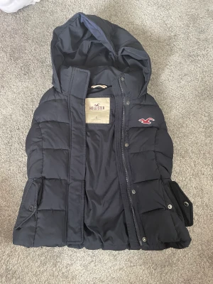 Hollister väst - Varm täckväst från Hollister i strl s. Fint skick, hel och ren! Mörkblå.