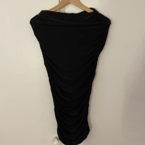 Kjol  - En svart tajt kjol från Boohoo. Den är rynkad vid sidorna så de framhäver ens kurvor. 