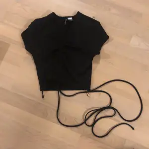 En svart tröja som man knyter runt midjan, från h&m strl xs. Oanvänd o i gott skick.