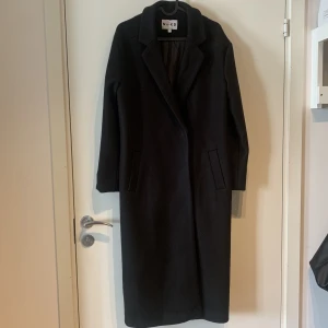 Svart kappa - Svart kappa från Na-kd. Knappt använt. Perfekt kappa till höst/vinter. Oversize känsla.