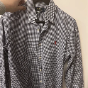 Randig Ralph Lauren skjorta. Vit/Blå - En otroligt fin, randig och stilig  Ralph Lauren skjorta. Ny pris ca 1399 kr. Skicket är 10/10 och skulle jätte gärna använda mer men den är för tyvärr för liten för mig!  Hör av dig vid eventuella frågor!:)