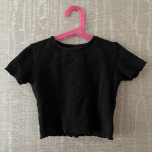 Svart babytee | Pull and Bear - En jättesöt svart croppad babytee från Pull and Bear i storlek S. Den är lite ”rouchad” i armarna och botten. Den är väldigt tjock i materialet. Säljer då den är för liten i armarna. Skriv för mer info och bilder.