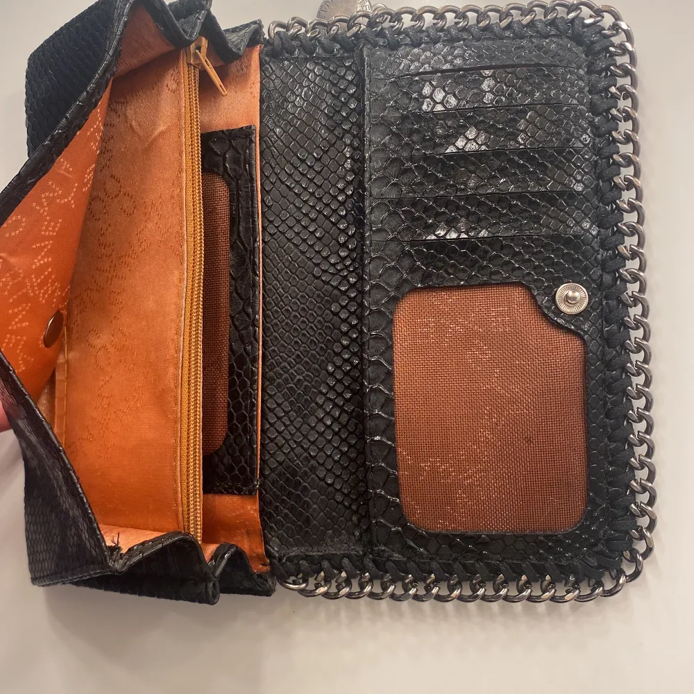 Säljer en Stella McCartney plånbok som jag tror är FEJK. Har lite defekter på metallhänge på bild 2 och knappen är lite känslig. Insidan ser orange ut men är mer åt det rosé rosa. Skriv om mer frågor eller bilder. Köparen står för frakten.❤️🥰. Accessoarer.
