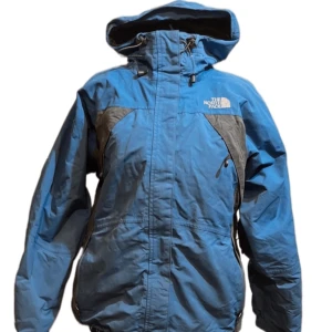The North Face jacka blå - Snygg, varm och skön jacka fran The North Face. Nice passform, funkar en hel vinter. En bit av bild försvann när bakgrunden av bilden togs bort men den delen är svart som på de andra bilderna. Dm för defekter. Läs min bio, dm för frågår och vid intresse. 