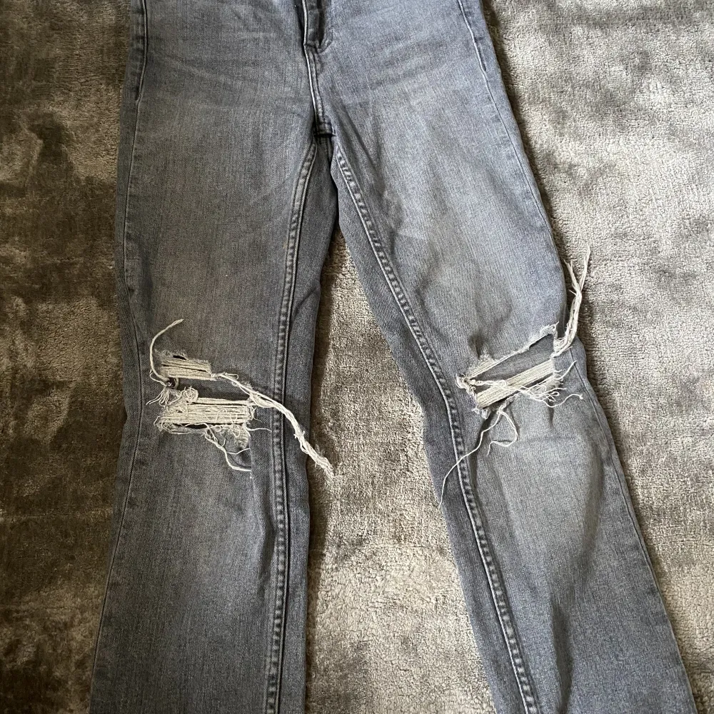 Ett par gråa bootcut jeans med hål och slits i från zara. . Jeans & Byxor.