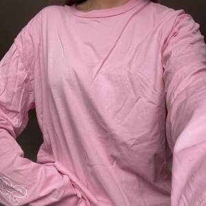 Rosa långärmad tröja stl L från Junkyard. En oversized tröja med tryck på ärmarna.