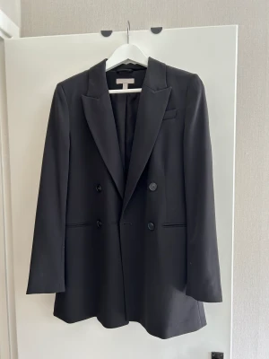 Kavaj, lång  - Lång svart kavaj, i gott skick. Skriv för fler bilder 