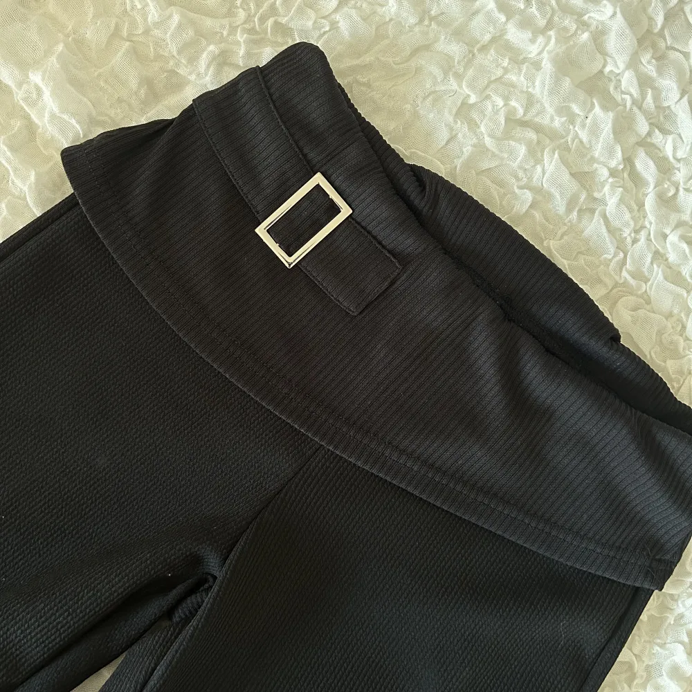Svarta utsvängda byxor med nedvikt kant och silver detalj. Nyskick storlek small. Jeans & Byxor.