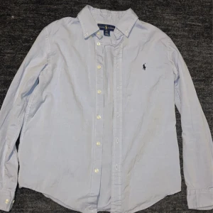 Polo Ralph Lauren Skjorta - Säljer denna fina Raffe skjortan. Passar XS. Skjortan är i väldigt bra skick. Nypris ca 1000kr - mitt pris - 249kr. Obs! I samband med köp av en annan skjorta i min profil landar de på 199kr/st. Skriv vid frågor!