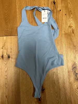 ljusblå body  - Helt oanvänd ljusblå body från NA-KD. 