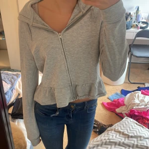 Zip up hoddie - En jätte fin zip up hoddie från hm  i storlek m som har söta volanger där nere på tröjan den är så skön och fin att ha på sig passar till verkligen allt.