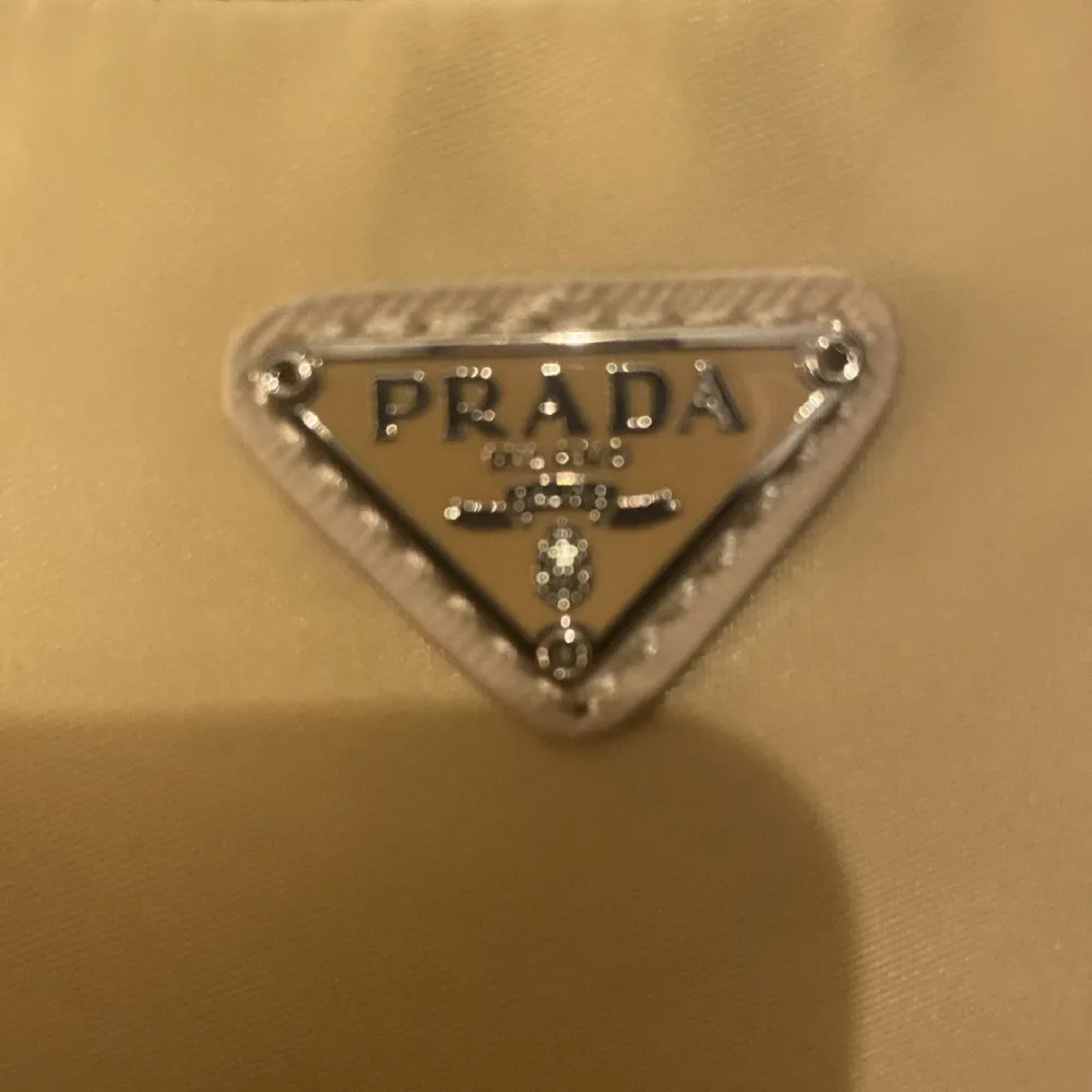 Beige prada väska. Helt oanvänd med alla tillbehör, låda, band osv. Det är en aaaa kopia jätte fin. . Väskor.