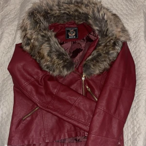 Vinröd ”skinn” jacka - Jacka från länge sedan som inte blivit använd och endast vart i garderoben.  Inte riktigt skinn och fejk päls :) Känns inte som riktigt. !!Katt finns i hemmet!! Priset går och diskuteras! 