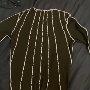 Långärmad tröja  - En fin svart tröja med vita sträck över på framsidan. Inga på baksidan.Den är i bra sick använt 1 gång för 1 år sedan aldrig igen.Tror ja köpte den på vero Moda men inte helt säker.Den är stretchig och jätteskön. Säljer pga att ja vill rensa min garderob!