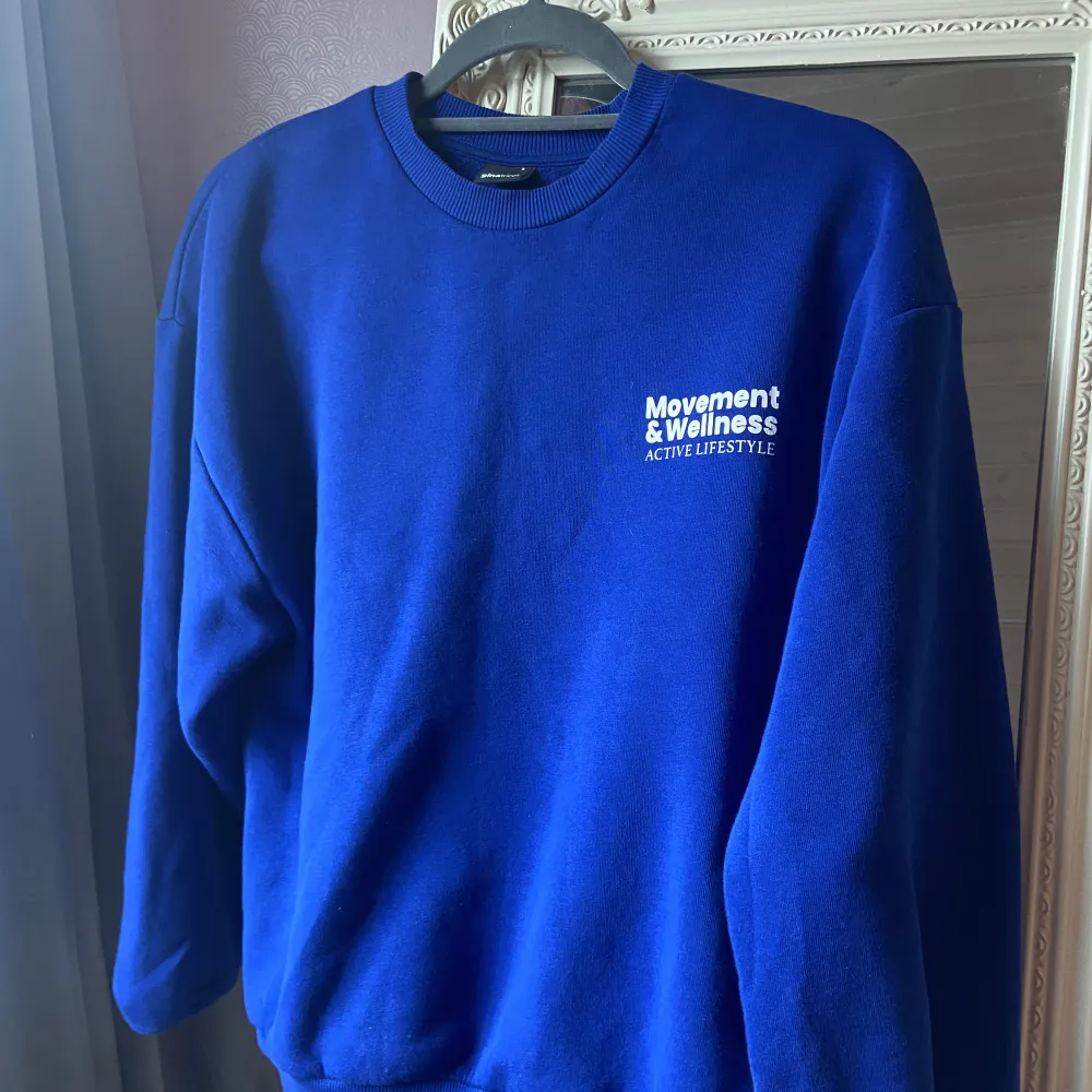 Säljer denna blå sweater ifrån Gina Tricot med tryck både fram och bak i ryggen💙💙 säljer då den köptes i fel storlek så den är som i (nyskick)  Frakten ingår i priset . Hoodies.