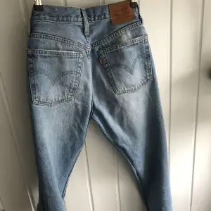 Långa Levis jeans, med hål på framsidan, de är i midrise och passar till 23-25, längd 32