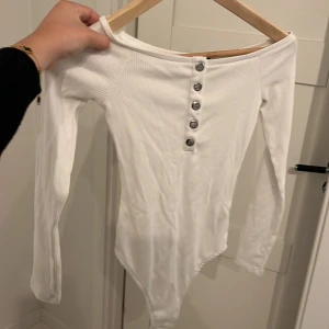 Ribbad body - Långärmad ribbad off shoulder body med 5 silver knappar 🩷🩷